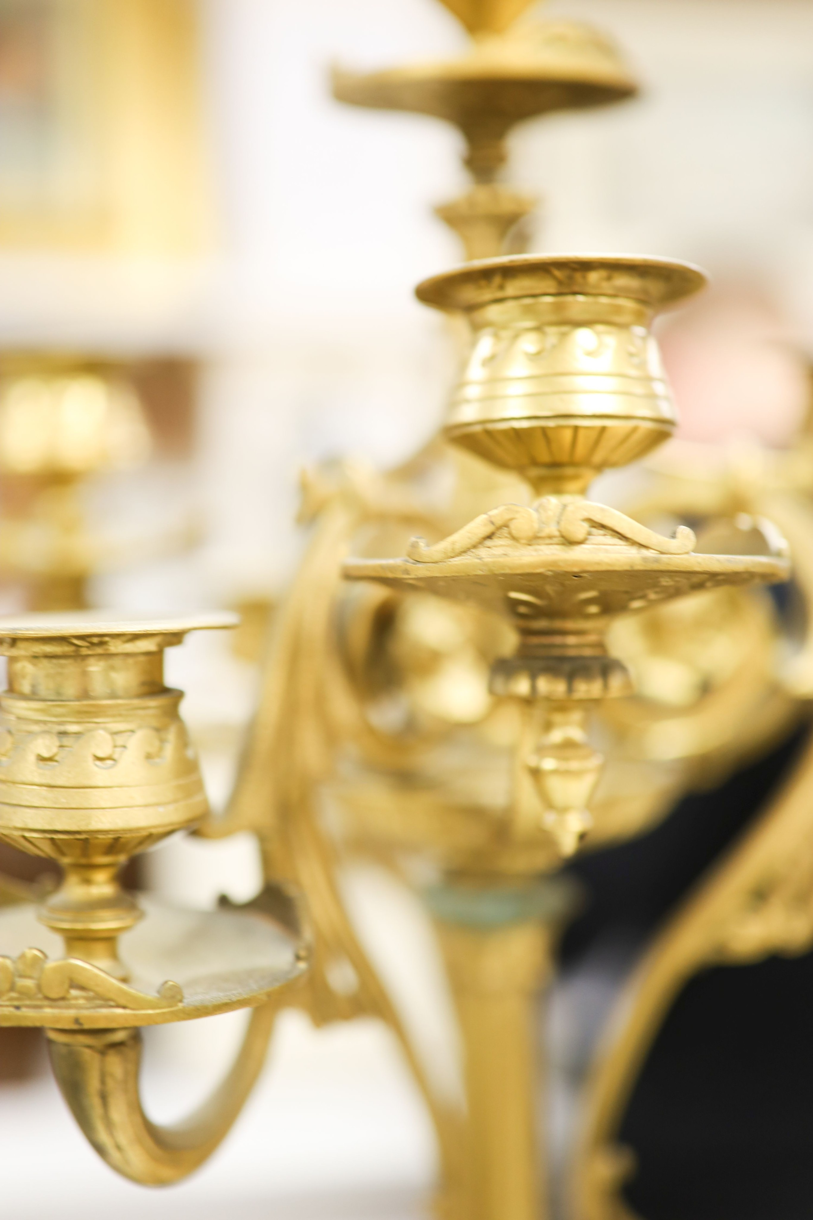 A pair of Louis XVI style four branch, five light gilt brass candelabra, with vase shaped stem, on shaped alabaster plinths 76cm